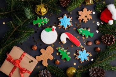 Noel kurabiyeleri geçmişi. Noel kurabiyesi, şekerli kurabiye ve köknar ağacı ve koyu arkaplanda Noel süsü. Noel arkaplanı, üst manzara, yukarıda, düz uzanma