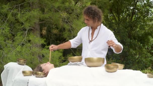 남자가 테베탄 노래를 부르는 그릇으로 여자를 치료하고 밖에서 소고를 부르는 — 비디오