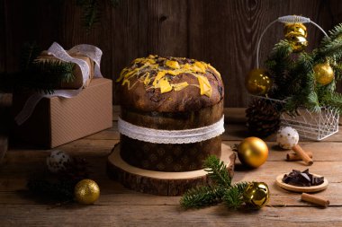 Geleneksel İtalyan Noel Keki Panettone beyaz kurdeleli ve ahşap arka planda şenlikli. Ev yapımı ekşi mayalı panettone klasik İtalyan Noel Yemeği Yenilebilir Hediye