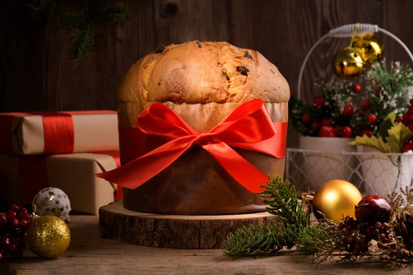 Tradycyjne Włoskie Ciasto Bożonarodzeniowe Panettone Czerwonym Łukiem Świąteczne Dekoracje Drewnianym — Zdjęcie stockowe