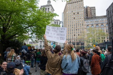 Elinde karton bir tabela tutan genç bir kadın 
