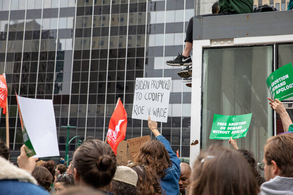 Молодая женщина держит картонный знак со словами "Байден обещал кодифицировать Roe v Wade", написанными на нем в Фоли-сквер, Нью-Йорк, США 05-03-2022 Протестующие держат плакаты