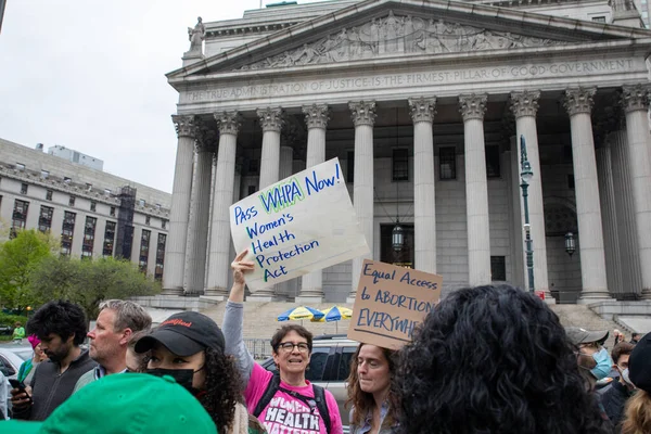 Genç bir kadın elinde karton bir tabela ile 