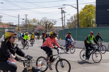 Bitiş çizgisine yakın Staten Island, New York 'taki Beş Boro Bisiklet Turuna motorcular katılıyor.