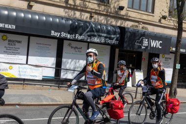 Bitiş çizgisine yakın Staten Island, New York 'taki Beş Boro Bisiklet Turuna motorcular katılıyor.