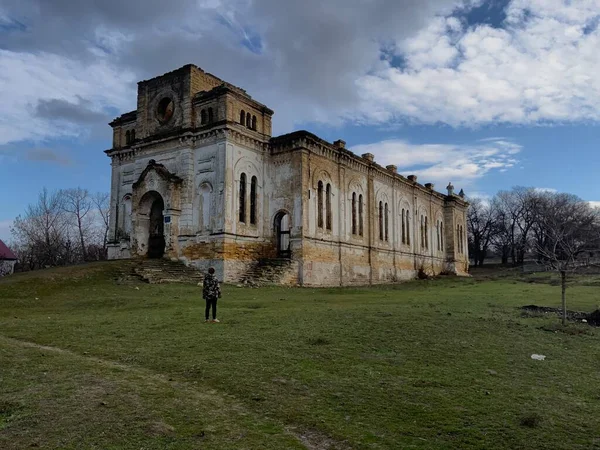 Зруйнований старий будинок у селі Україна. Дитина дивиться на старий будинок. — стокове фото