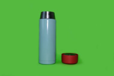 Parlak yeşil bir arka planda termos. Yüksek kalite fotoğraf.