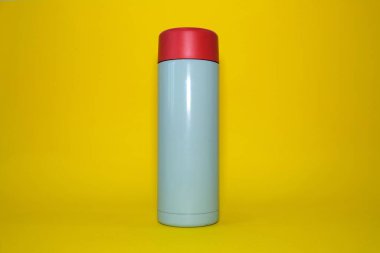 Parlak sarı bir arka planda termos. Yüksek kalite fotoğraf.