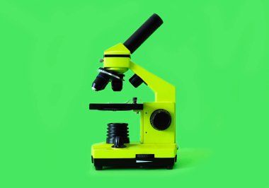 Microscope on a bright green background. High quality photo.