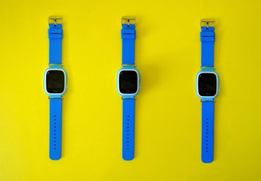 Parlak sarı arka planda GPS olan bir kol saati. Çocukların GPS saati