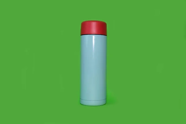 Thermos on a bright green background. High quality photo. — стоковое фото