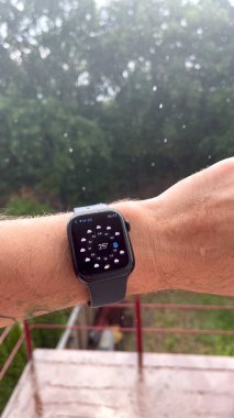 Bir erkeğin elindeki akıllı saat, yağmur yağıyor, hava durumunu gösteriyor. Yüksek kalite 4k görüntü