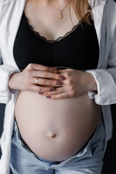 a pregnant woman holds the top of her stomach with both hands. Background image