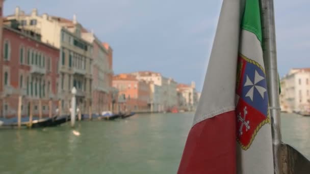 Die italienische Flagge weht während einer Bootsfahrt auf dem Canal Grande in Venedig, Italien, am Tag. Mittelalterliche Gebäude im Hintergrund, selektiver Fokus — Stockvideo