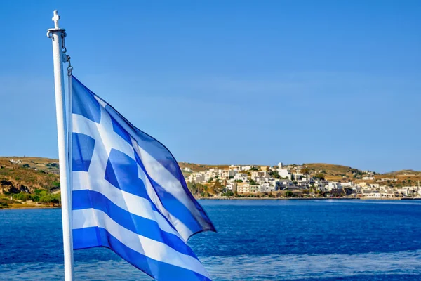 Bandeira grega acenando no fundo típico da paisagem da ilha grega borrada. Brilhante dia de verão. Ilha saltando, aventuras e explorar o mar Mediterrâneo. — Fotografia de Stock
