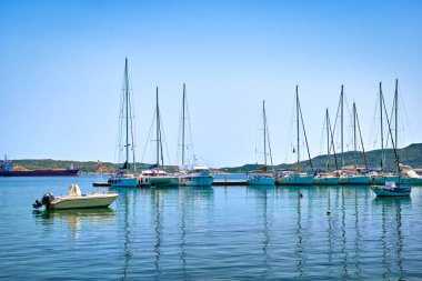 Akdeniz, Yunan adası, açık mavi gökyüzü ve deniz sularında yelkenli yatlar ve tekneler. Yaz eğlencesi, eğlence yelkencilik, balıkçılık, hobi