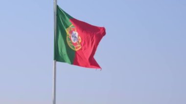 National flag of Portugal waving in the wind from left to right on a clear sunny day at blue sky. Patriotism, democracy, politics, nation, European union member country. Real 4k footage.
