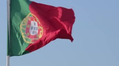 Close view of national flag of Portugal waving in the wind from left to right on a clear sunny day at blue sky. Patriotism, democracy, politics, nation, European union member country. Real 4k footage.
