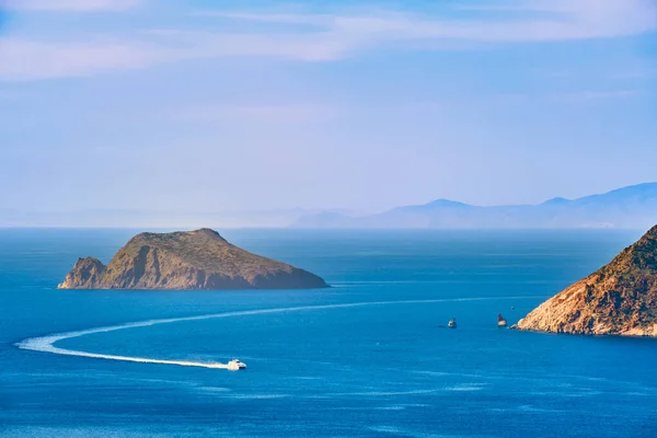 美丽的风景 海湾里有几个小岛 遥远的朦胧的海岸 蓝色的海水 广阔的天空 地中海阳光灿烂的夏日 小船驶入风景如画的港湾 完美的希腊人 — 图库照片