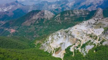 Apuan Alps, Carrara, İtalya 'daki mermer ocağının yavaş hava görüntüsü. Güneşli bir günde panoramik drone görüntüsü, ünlü beyaz Carrara mermeri Antik Roma 'dan beri kazılmış, birçok başyapıt için kullanılmış,