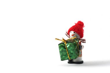 Beyaz arka planda yeşil kağıda sarılı hediye kardan adam. Resim kopyalama alanı içeriyor