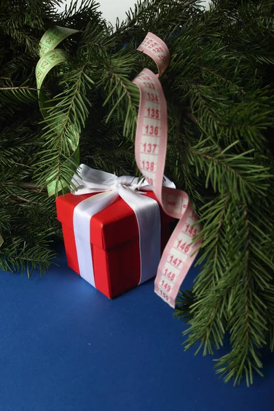 Kerstconcept Geschenkdoos Centimeters Dennenboomtakken Blauwe Achtergrond — Stockfoto