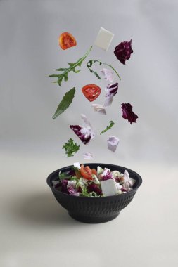 Sağlıklı beslenme konsepti. Salata kesesi, arka planda ışığa karşı siyah kaseye dönüşür. Resim kopyalama alanı içeriyor