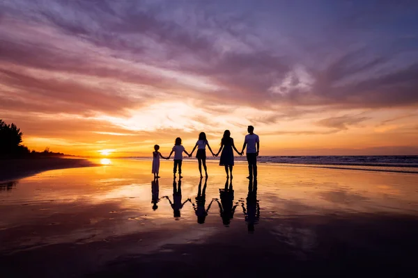 Silhouetten Van Gelukkige Familie Die Handen Het Strand Houden Tijdens — Stockfoto