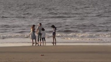 Aile, eğlence ve insanların konsept olarak büyük aileleri tropik plajlarda suda yalınayak koşup oynuyorlar..