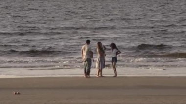 Aile, eğlence ve insanların konsept olarak büyük aileleri tropik plajlarda suda yalınayak koşup oynuyorlar..