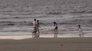 Aile, eğlence ve insanların konsept olarak büyük aileleri tropik plajlarda suda yalınayak koşup oynuyorlar..