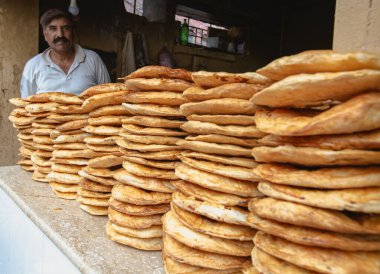 RAWALPINDI, PAKISTAN - Eylül 2021: Pakistanlı adam Rawalpindi, Pakistan 'da Raja Pazarı' nda ekmek satıyor