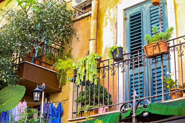 TAORMINA, ITALY - November 2021: Colorful old house balcony with flowers decoration in old town of Taormina, Sicily, Italy