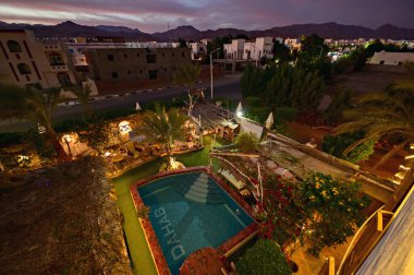 DAHAB, EGYPT - December 2021:  Beautiful house, villa, resort with swimming pool in Dahab, Egypt. Picture from above at sunset, Sinai, Dahab