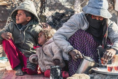 DAHAB, EGYPT - Şubat 2022: Bedevi ailesi Güney Sina, Mısır 'da ateşin yanında çay içiyor