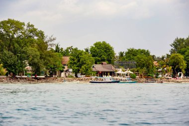 GILI, INDONESIA - Şubat 2020: Beyaz kum plajı ve Endonezya 'nın güzel Gili Meno adasındaki tekneler