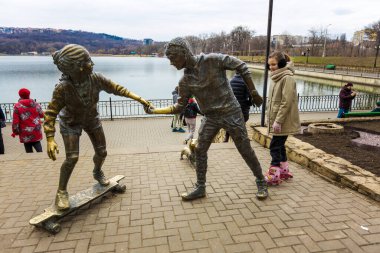 CHISINAU, MOLDOVA-Mart 2022: Genç çift ve Basset Hound köpek heykeli Valea Morilor Park, Moldova 'da Petru Glavan tarafından yapıldı