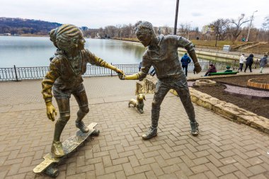 CHISINAU, MOLDOVA-Mart 2022: Genç çift ve Basset Hound köpek heykeli Valea Morilor Park, Moldova 'da Petru Glavan tarafından yapıldı