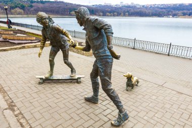 CHISINAU, MOLDOVA-Mart 2022: Genç çift ve Basset Hound köpek heykeli Valea Morilor Park, Moldova 'da Petru Glavan tarafından yapıldı