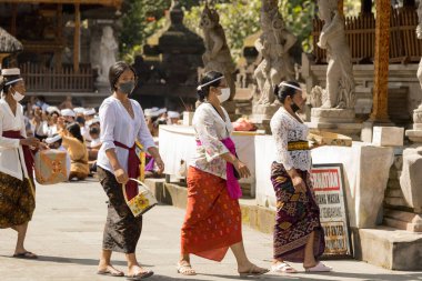 BALI, INDONEZYA - Nisan 2022: Endonezya 'nın Bali kentindeki Tirta Empul tapınağında düzenlenen törende Balili insanlar