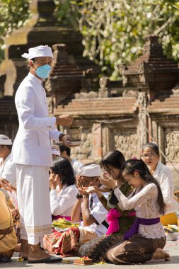 BALI, INDONEZYA - Nisan 2022: Endonezya 'nın Bali kentindeki Tirta Empul tapınağında düzenlenen törende Balili insanlar