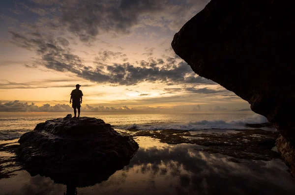 BALI, INDONEZYA - Nisan 2022: Endonezya 'nın Bali kentindeki Tanah Lot tapınağının yakınındaki taşın üzerindeki insan silueti