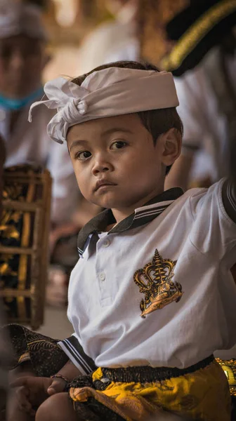 BALI, INDONEZYA - Nisan 2022: Endonezya 'daki Bali tapınağında geleneksel törende geleneksel kostüm giyen sevimli küçük Balili çocuk