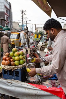 RAWALPINDI, PAKISTAN - Eylül 2021: Pakistanlı adam Rawalpindi, Pakistan 'da taze meyve suyu hazırlıyor