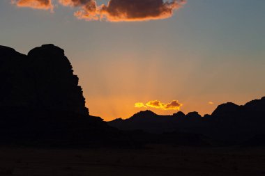 Wadi Rum çölde gün batımı. Turuncu günbatımı gökyüzü ve bulutlar Wadi Rum, Jordan