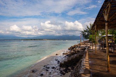 Sabahları deniz manzarası, huzurlu deniz kıyısı ve bulutlu bir arka plan.