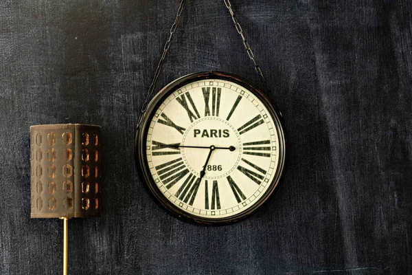 Clock on the dark wall with writing Paris and the lamp, living room attributes, Canada