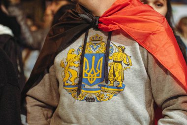 İsrail 'de Ukrayna' yı desteklemek için düzenlenen mitingde Ukrayna amblemi taşıyan bir sweatshirt giyen bir adam.