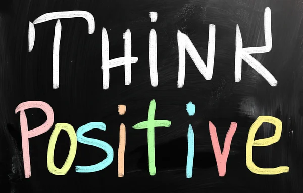 "Tänk positivt "handskrivet med vit krita på en svart tavla — Stockfoto
