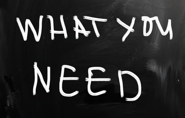 "What you need" handwritten with white chalk on a blackboard — Stock Photo, Image